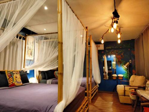 een slaapkamer met een hemelbed en gordijnen bij Nego Home Ancient Inn in Bangkok