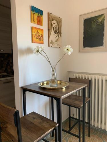 a table with a vase on it with flowers on it at A Casa Così B&b in Marzocca di Senigallia