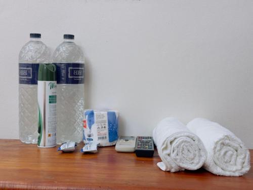 a wooden shelf with towels and bottles of water at Hotel Rose Garden Palace Residential in Dhaka
