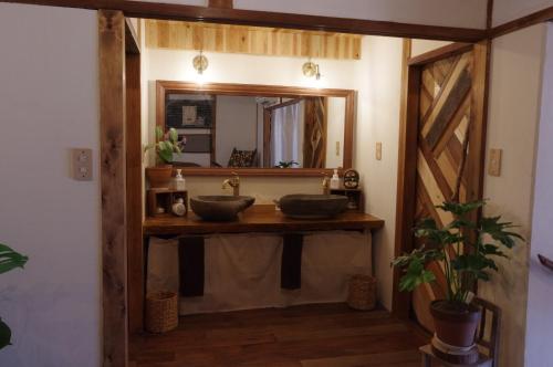 a bathroom with two sinks and a mirror at 宿たぬきのねどこ GUESTHOUSE TANUKI in Tokoname