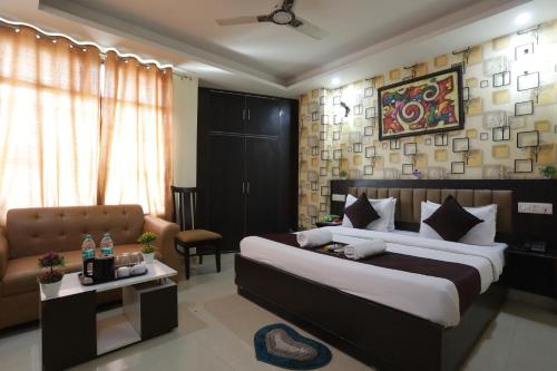 a bedroom with a king sized bed and a couch at HOTEL DV PLAZA INN in New Delhi