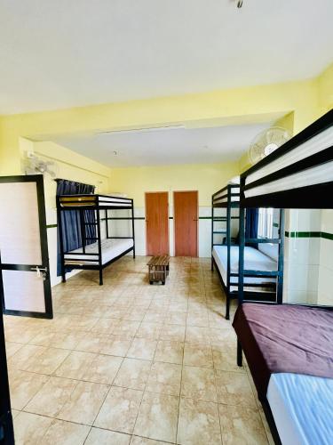 a room with three bunk beds and a tiled floor at Liba rooms panamaram in Panamaram