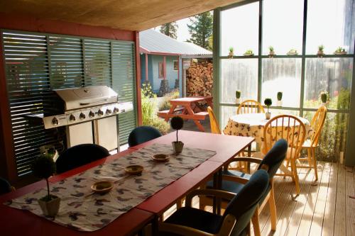 eine Terrasse mit einem Tisch, Stühlen und einem Herd in der Unterkunft Adventure Lodge and Motels and Tongariro Crossing Track Transport in National Park