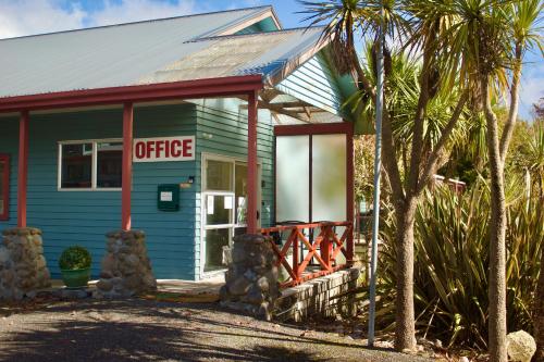 a office building with palm trees in front of it at Adventure Lodge and Motels and Tongariro Crossing Track Transport in National Park