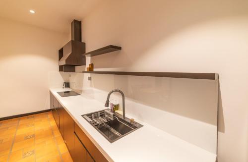 a kitchen with a sink and a stove at Brick House Dalat Hotel in Da Lat
