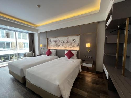 ein Hotelzimmer mit 2 Betten und einem großen Fenster in der Unterkunft Lovina Haven Boutique Resort in Lovina