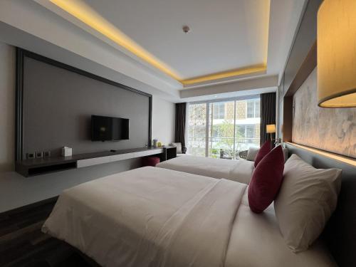 ein Hotelzimmer mit 2 Betten und einem Flachbild-TV in der Unterkunft Lovina Haven Boutique Resort in Lovina