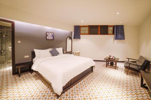 a bedroom with a large white bed in a room at Brick House Dalat Hotel in Da Lat