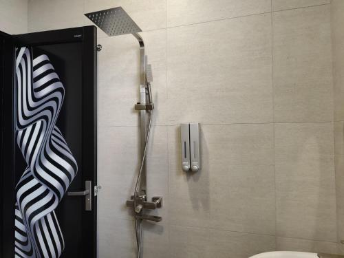 a shower in a bathroom with a black door at Ipoh Eden Pool Villa Suites in Ipoh