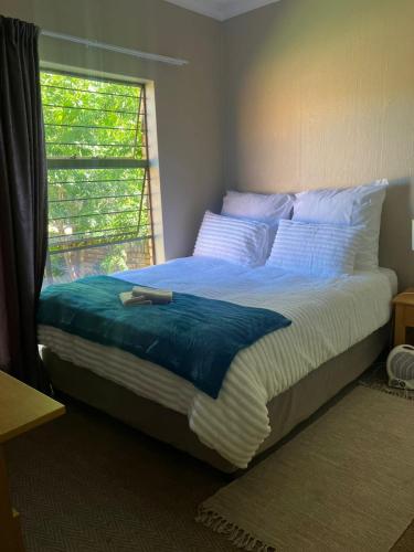 a bedroom with a large bed with a window at Secure Townhouse Bedroom Immediately Available in Roodepoort