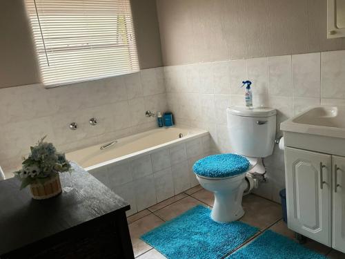 a bathroom with a toilet and a tub and a sink at Secure Townhouse Bedroom Immediately Available in Roodepoort