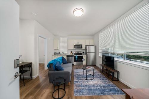 a living room with a couch and a kitchen at Urban Living: Stylish Apts in the Heart of Tacoma in Tacoma