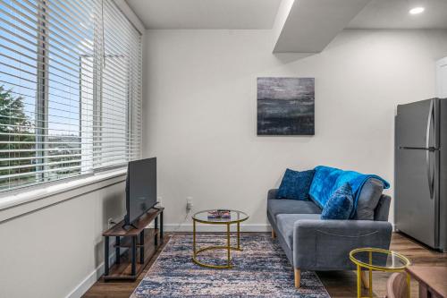 a living room with a couch and a tv at Urban Living: Stylish Apts in the Heart of Tacoma in Tacoma