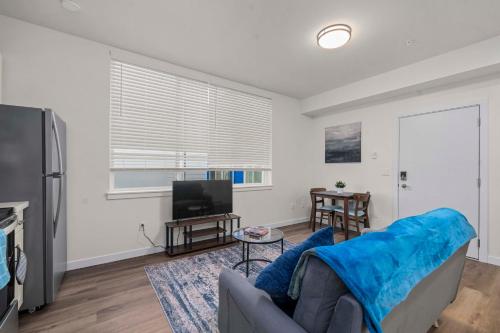 a living room with a couch and a television at Urban Living: Stylish Apts in the Heart of Tacoma in Tacoma
