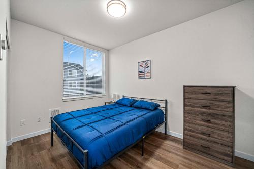 a bedroom with a bed and a dresser and a window at Urban Living: Stylish Apts in the Heart of Tacoma in Tacoma