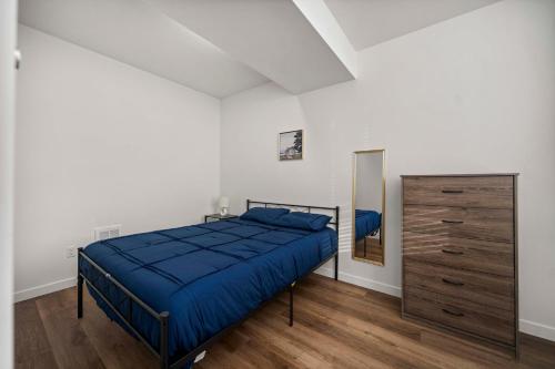 a bedroom with a bed and a dresser and a mirror at Urban Living: Stylish Apts in the Heart of Tacoma in Tacoma