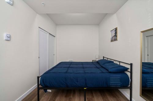 a bedroom with a bed with a blue comforter at Urban Living: Stylish Apts in the Heart of Tacoma in Tacoma