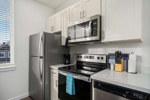 a kitchen with a stainless steel stove and microwave at Urban Living: Stylish Apts in the Heart of Tacoma in Tacoma
