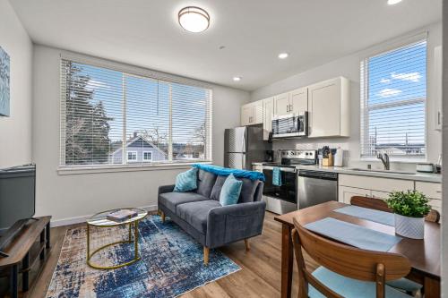 a kitchen and living room with a couch and a table at Urban Living: Stylish Apts in the Heart of Tacoma in Tacoma