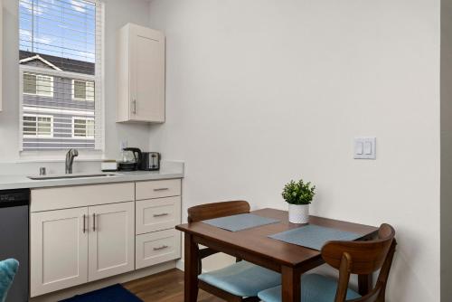 a kitchen with a table and chairs and a sink at Urban Living: Stylish Apts in the Heart of Tacoma in Tacoma
