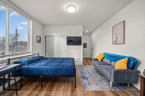 a bedroom with a blue bed and a couch at Urban Living: Stylish Apts in the Heart of Tacoma in Tacoma