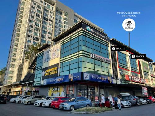 um grande edifício com carros estacionados num parque de estacionamento em MetroCity Backpackers em Kuching
