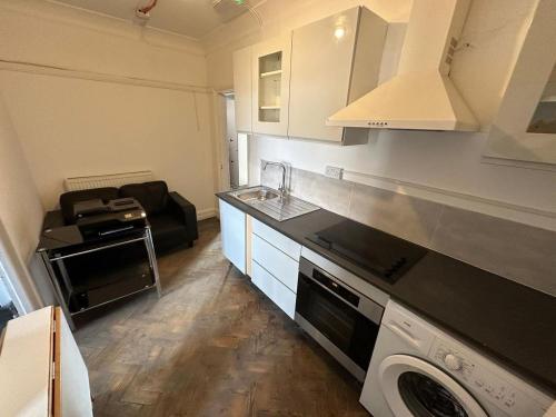 a kitchen with a washer and dryer in a room at The Hyde Arms in Edmonton