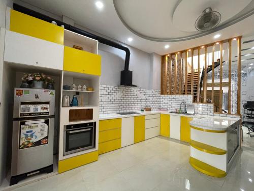 uma cozinha com armários amarelos e brancos e um frigorífico em CASA Camping House em Tuy Hoa