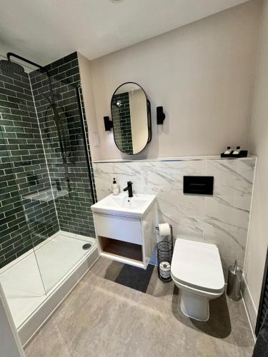 uma casa de banho com um lavatório, um chuveiro e um WC. em Luxury Leeds City Centre 1 Bedroom Flat em Leeds