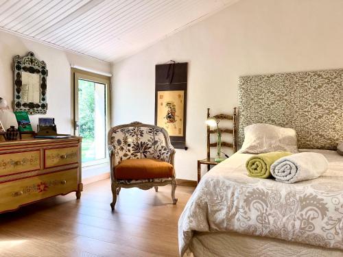 une chambre avec un lit, une commode et une chaise dans l'établissement Villa Melodie St Remy 6HA Piscine, à Saint-Rémy-de-Provence
