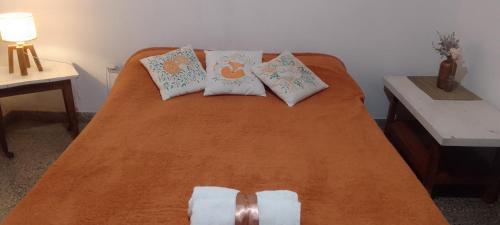 a bed with three pillows on it in a room at HOSPEDAJE " La Catalina " Ubicada a 15 minutos del Aeropuerto Internacional de Ezeiza con Estacionamiento in Tristán Suárez