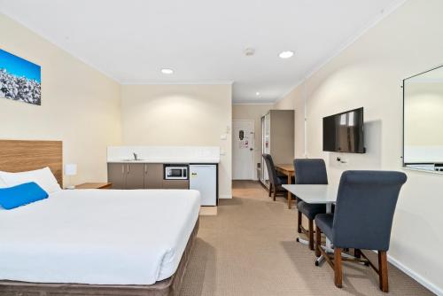 a hotel room with a bed and a table and chairs at Comfort Inn Bishops Lodge in Hay