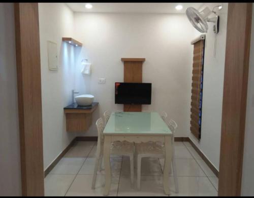 ein kleines Esszimmer mit einem Tisch und einem TV in der Unterkunft Natural king Queen residency in Sultan Bathery