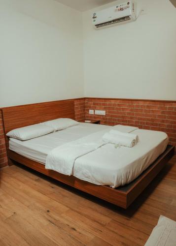 a bed in a room with a brick wall at Waves and Shores Beach Villa in Mararikulam