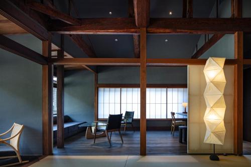 a room with chairs and a table and windows at Kobayashiya -Kinosaki Onsen- in Toyooka