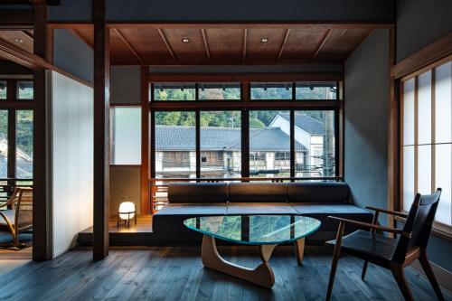 a living room with a glass table and a couch at Kobayashiya -Kinosaki Onsen- in Toyooka