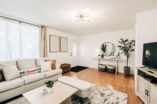 sala de estar con sofá blanco y TV en Bright, chic & spacious in the heart of St. Paul by Summit-University with porch and swing chairs, en Saint Paul