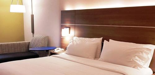 a hotel room with a bed and a chair at Holiday Inn Express and Suites Surrey by IHG in Surrey