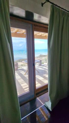 a window in a room with a view of the ocean at Tendu' Punta Bianca Glamping Camp in Palma di Montechiaro