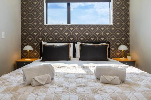 1 dormitorio con 1 cama grande y 2 lámparas en Luxury Without Limits in CBD Christchurch, en Christchurch