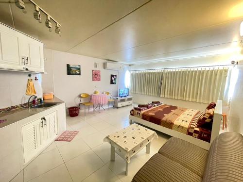 a living room with a bed and a table at Lovely Impact C3-C9 Lily in Nonthaburi