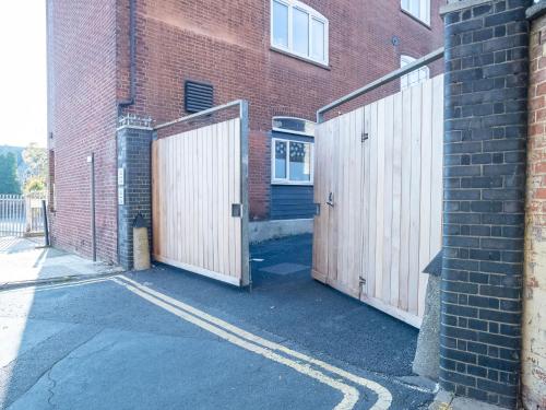 two wooden gates on the side of a brick building at Modern Apartment Ipswich near Christchurch Park Ipswich Waterfront by Sojo Stay in Ipswich