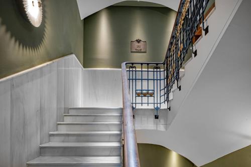a staircase in a building with a green wall at Palacio Santa Clara, Autograph Collection in Valencia
