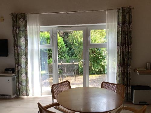 a table and chairs in front of a sliding glass door at Landleben - Ferienhaus 2 in Fritzlar