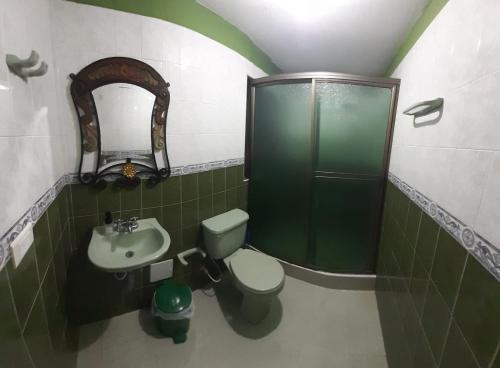 uma casa de banho com um chuveiro, um WC e um lavatório. em Casa Hotel Villa Lunita em Villa de Leyva