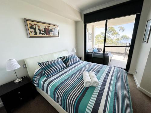 a bedroom with a bed with two towels on it at Rockingham Waterfront at Nautilus in Rockingham