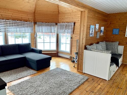 ein Wohnzimmer mit einem Sofa und einigen Fenstern in der Unterkunft Villa Venekoski in Jyväskylä