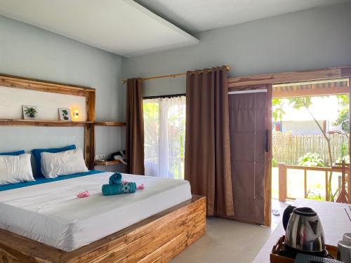 1 dormitorio con 1 cama grande y balcón en Marta House gili air, en Gili Air