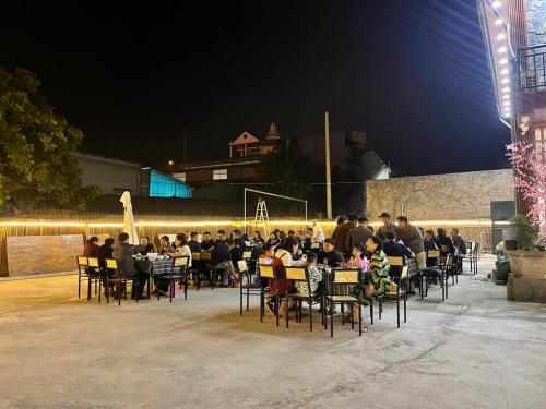 a group of people sitting at tables at night at mộc châu homestay in Làng Môn