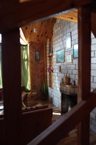 sala de estar con chimenea y pared de piedra en The Vintage Inn by suman cottage, en Manali